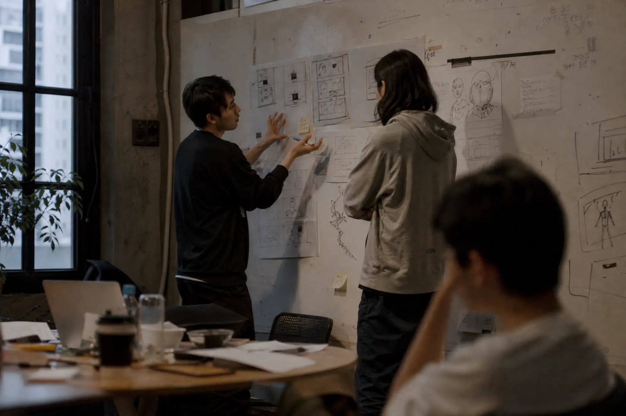 Designers discussing a storyboard on a studio whiteboard