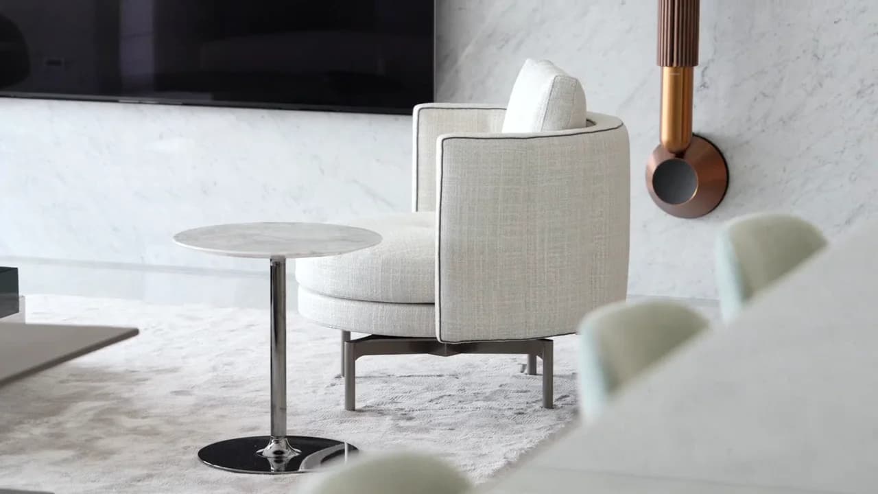 A quiet URBANE interior with pale upholstery, marble, and sculptural copper wall lighting